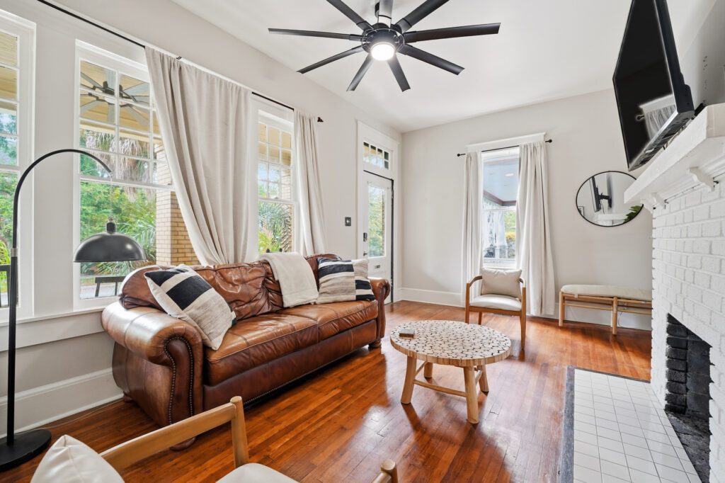 Monthly Furnished Rentals in Jacksonville: Plan a Longer Stay 1 Sunlit living room with a brown leather sofa at the Springfield three-bedroom rental