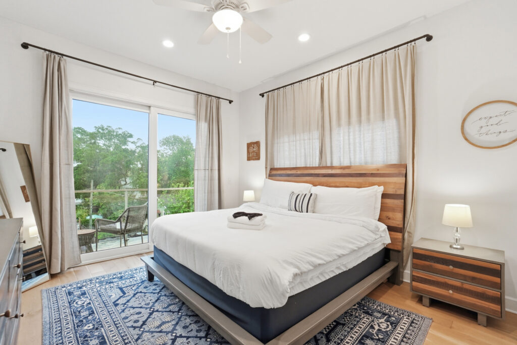 White bedding and folded towels in a JaxBNB vacation rental bedroom in San Marco